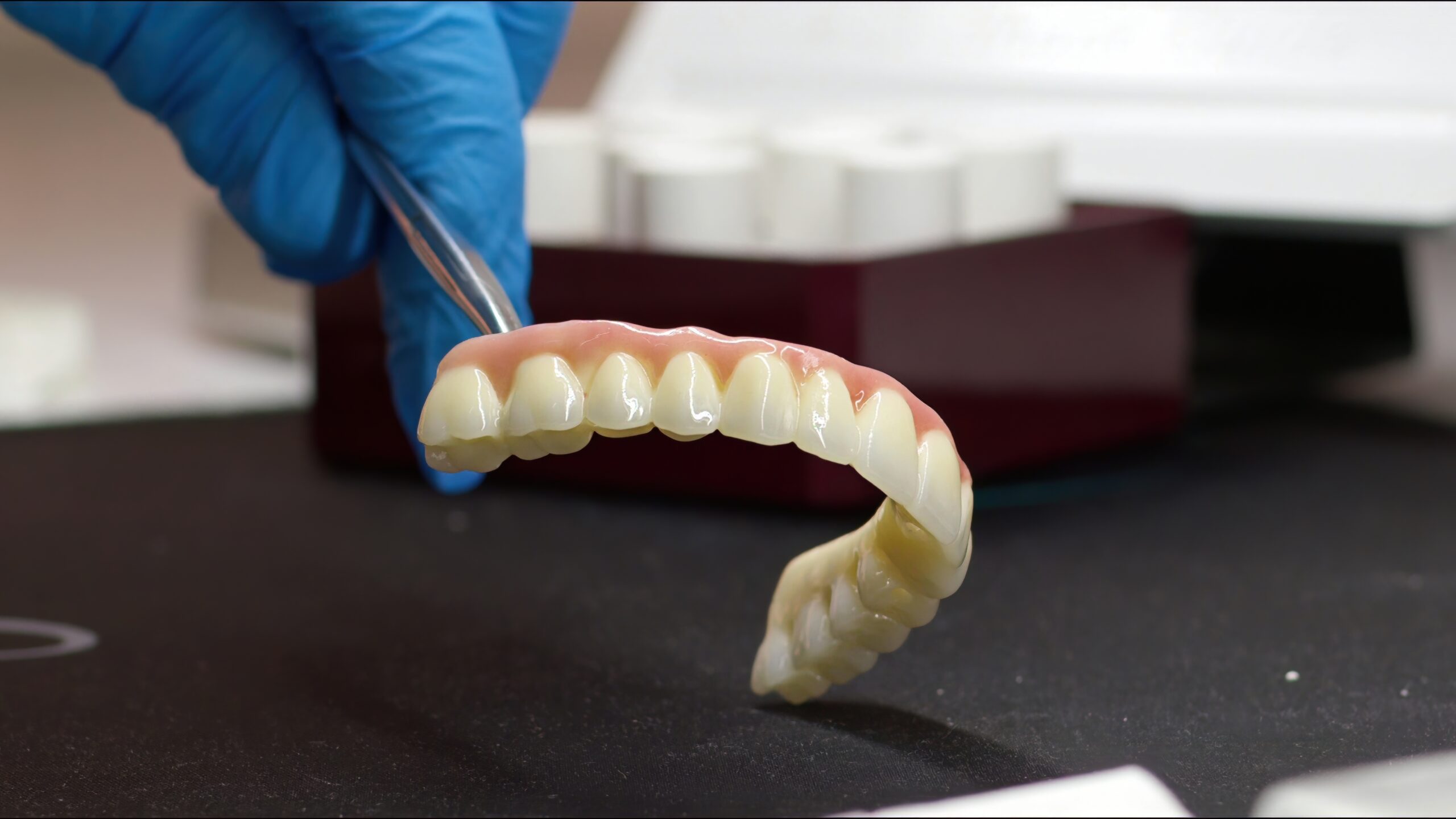 Zirconia dental bridge held with tweezers at Avira Dental, crowns and bridges in Penrith